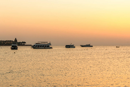 船剪影在红海的海岸在日落在埃及马卡迪湾金色