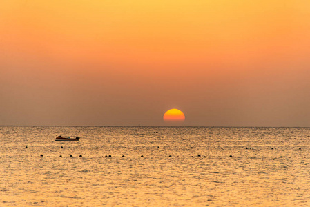 船剪影在红海的海岸在日落在埃及马卡迪湾金色