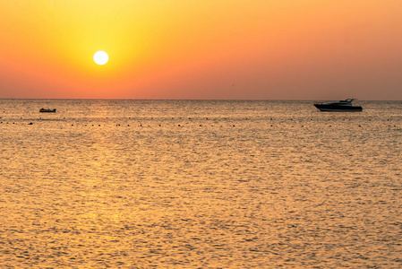 船剪影在红海的海岸在日落在埃及马卡迪湾金色