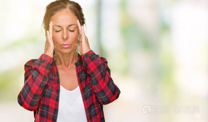 中年成年妇女穿着休闲夹克，在孤立的背景上，手在头上疼痛，因为压力。 偏头痛。
