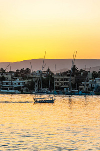 在埃及卢克索金色多彩的日落时, 您可以欣赏尼罗河的景色, 有帆船