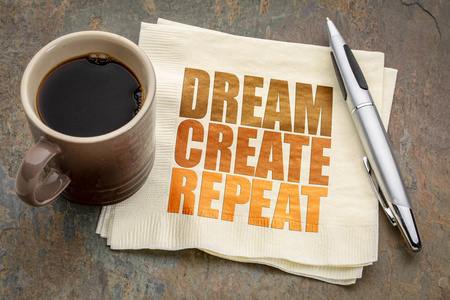 梦想创造重复鼓舞人心的概念单词摘要在餐巾纸上与一杯咖啡