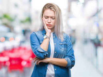 年轻的金发女人在孤立的背景下，认为疲劳和无聊的抑郁问题与交叉的手臂。