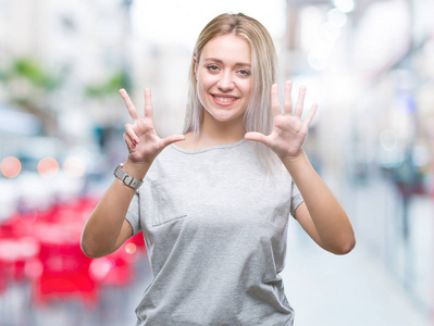 年轻的金发女子在孤立的背景显示和指着8号手指，同时微笑自信和快乐。