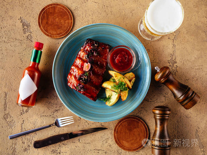 烤纹状体切片牛排和啤酒在石桌上. 顶部视图