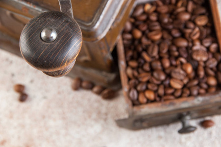 旧的棕色金属咖啡磨床专注于木制手柄，靠近混凝土背景。 复制文本空间。