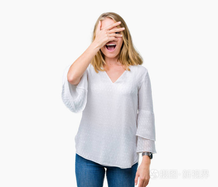美丽的年轻优雅的女人在孤立的背景上偷看震惊,覆盖着脸和眼睛,用手