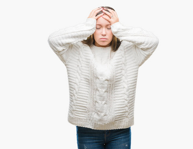 年轻美丽的白种人女人穿着冬季毛衣，在孤立的背景下，因为头痛绝望和压力，因为疼痛和偏头痛。 手放在头上。