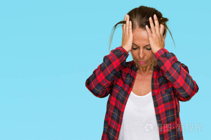 中年成年妇女穿着休闲夹克，在孤立的背景下患有头痛，绝望和压力，因为疼痛和偏头痛。 手放在头上。