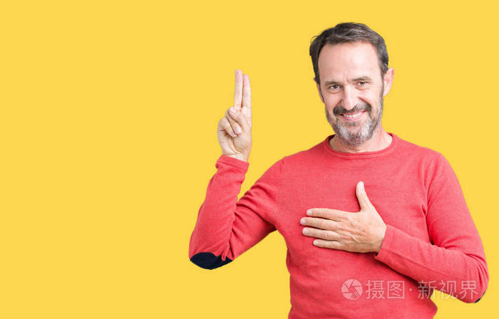 英俊的中年老人穿着冬天的毛衣背景偏僻用手捂住胸口和手指发誓许下