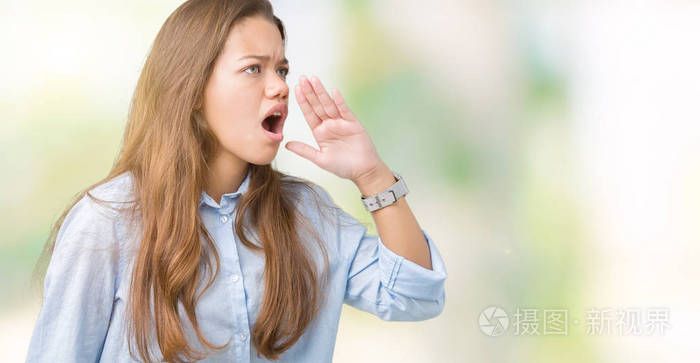 年轻漂亮的黑发商务女性在孤立的背景上大声喊叫，并大声尖叫，手在嘴上。传播概念。