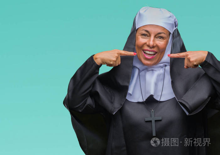 中年基督教天主教修女妇女,在孤独的背景下微笑,自信地展示和手指