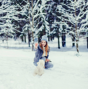 快乐美丽的年轻女子在冬天玩耍。友谊，宠物和人类