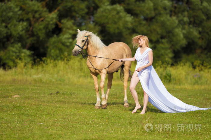一位年轻的骑手,金发碧眼,身穿白色连衣裙,马背上有一片田野和森林