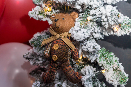 戴着围巾的玩具熊挂在圣诞节的树枝上