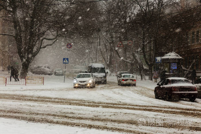 冬天城市街道上的大雪汽车上覆盖着雪滑的道路冬天的坏天气大雪和暴风