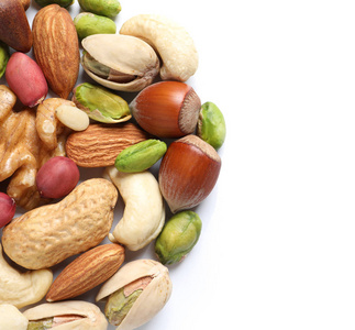 白色背景上的混合有机坚果堆照片
