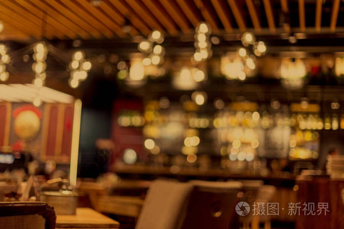 一家小餐馆的内部背景模糊. 模糊的bokeh咖啡馆内部温暖的深色.