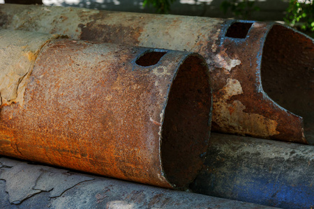 旧大水管的碎片。 经过多年的运行，破坏的金属管道被破坏。 有孔腐蚀的蔬菜钢管。 生锈的金属管。 选择性聚焦