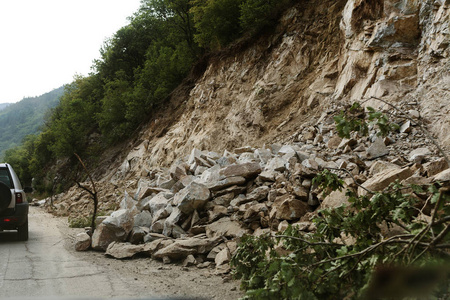 山体滑坡石坡威胁堵塞道路和森林道路。 危险的落基山脚下城市的司机和居民面临的危险