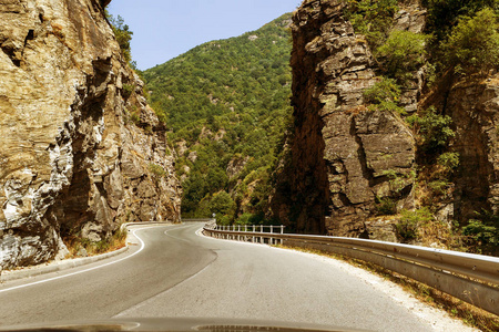 蜿蜒的山路..山区的双向道路。在石质山坡附近的山区铺设公路