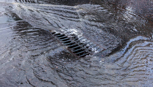 肮脏的污水在路上流动.废水排放排水系统不起作用照片