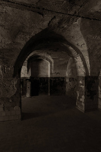 地下酒窖里一条废弃的老隧道..地下墓穴入口。地牢.老石堡垒..作为策划黑暗设计的创意背景。古代地牢神秘的内部