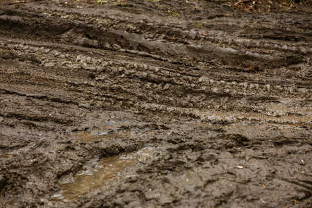 汽车轮胎在粘土上的污垢滑印。 土路上的车轮路。 春天潮湿的肮脏的粘土路。 跟踪极端驾驶离开道路。 从车上追踪。 背景软短焦点