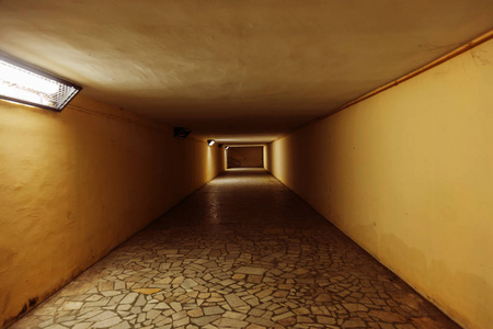 神秘的主题隧道，漫长的阴郁走廊进入未知的光线在隧道的尽头。 社会学不可解决问题的无限不确定性概念说明