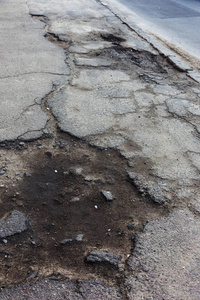 损坏的道路开裂沥青剑与坑坑洼洼和斑点乌克兰。 很差的沥青路，有很大的洞。 可怕的技术建设道路。 无数次危险的失败。 糟糕的路。 