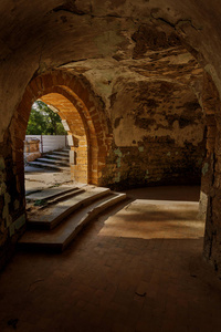 地下酒窖里一条废弃的旧隧道。 地下墓穴的入口。 地牢老石堡垒。 作为进行黑暗设计的创造性背景。 古代地牢的神秘内部