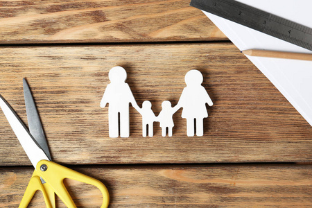 平躺构图，家庭人物和剪刀在木制背景上。 人寿保险概念