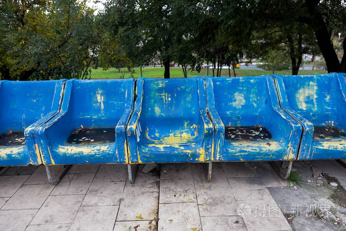 为重要的风扇访客划伤磨损的蓝色塑料座椅.