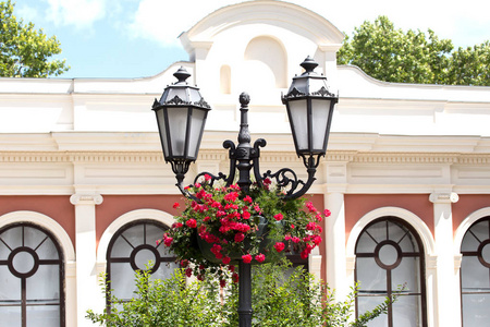 原装复古风格的路灯。 夏季城市的街道照明。 在特殊的花篮颜色的照明柱。 复古风格的城市装饰。