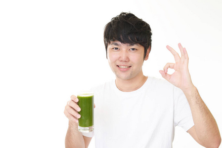 亚洲人喝一杯蔬菜汁。