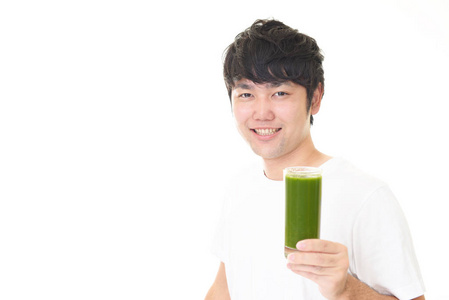 亚洲人喝一杯蔬菜汁。