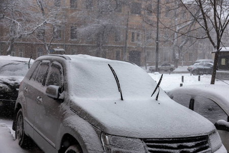 冬天城市街道上的大雪。 汽车上覆盖着雪滑的道路。 冬天的坏天气大雪和暴风雪。 行人在大雪下行走。 冬天和暴风雪