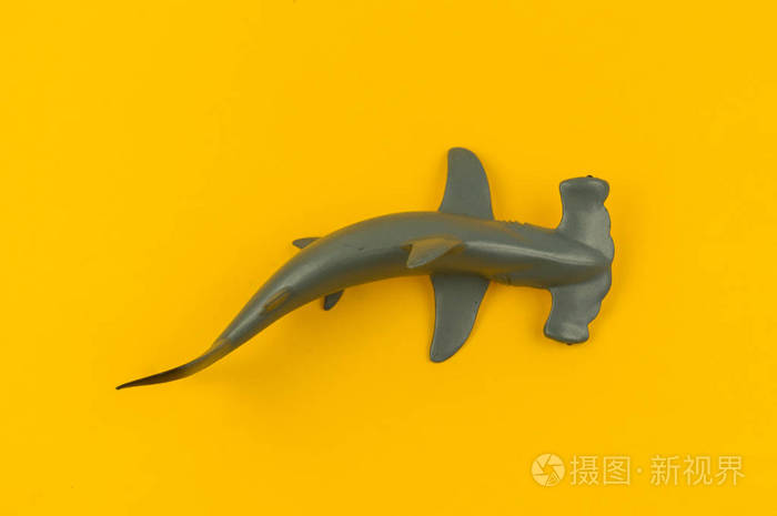 玩具锤鱼从塑料黄色背景 儿童用的海洋动物.
