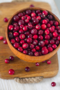 木制表面碗中的新鲜蔓越莓