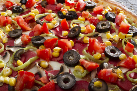 近距离观看意大利披萨与奶酪，辛辣，绿色，墨西哥胡椒，切片橄榄和火腿