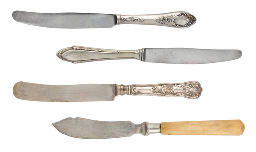 老式磨损的勺子叉子和刀在白色背景上隔离。 复古银器