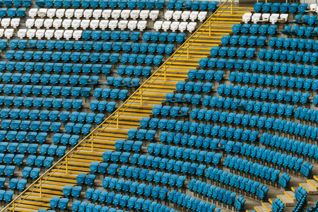 体育场看台上空荡荡的旧塑料椅子。 看台上有许多观众的空座位。 足球迷的空塑料椅子座位。 无观众的论坛赛