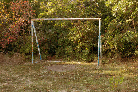 城市公园森林区践踏草坪上迷你足球的旧铁生锈足球球门。 公园里的旧小足球门。 农村草地中央的手足球大门