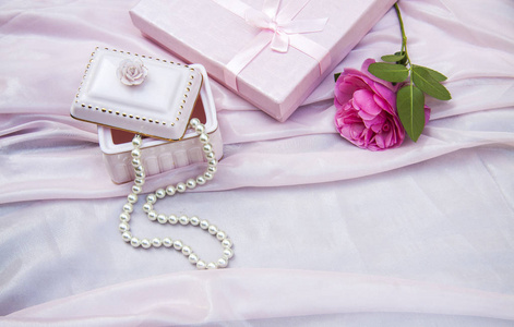 粉红色的背景与一个盒子和珠珠