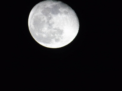 一张令人惊叹的照片，拍摄于热那瓦市上空的满月，背景是晴朗的天空和一些星星
