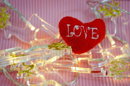 情人节。红色的心和灯光花环在粉红色的背景。