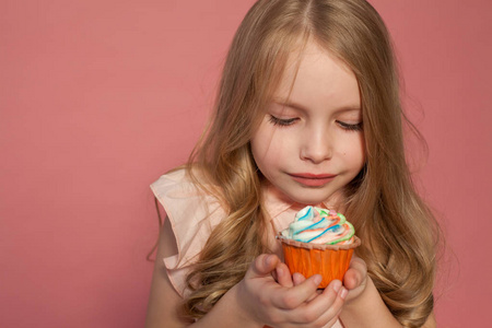 小女孩吃蛋糕与奶油纸杯蛋糕甜