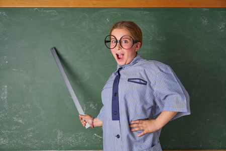 带着绿色黑板的老师服装和学校规则的滑稽女孩