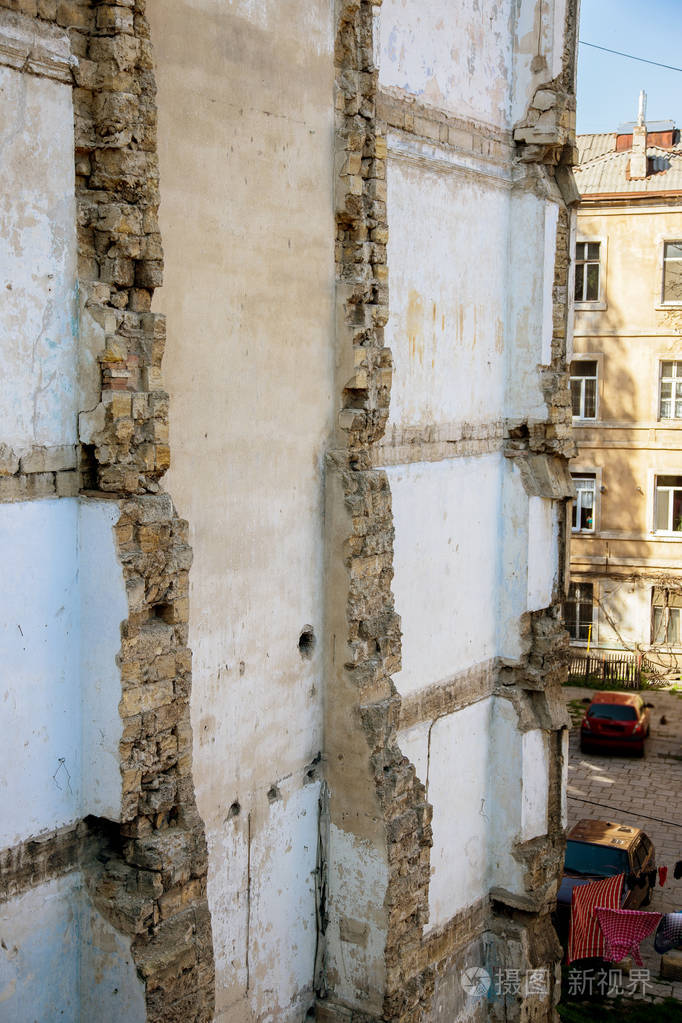 粉刷差墙面.grungy宽砖墙.红色的背景.用破损的石膏擦拭建筑立面.