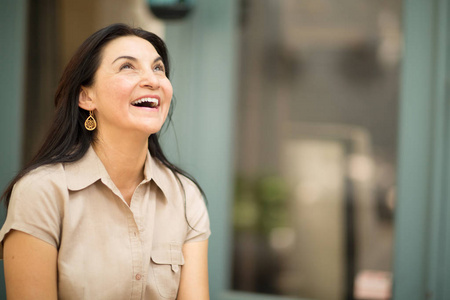 幸福的西班牙裔女人微笑着站在外面